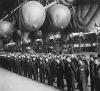 Balões barragem britânicos seguramente guardados no seu hangar para a noite. Operadores de balões da WAAF apresentam-se para inspecção antes de serem dispensados depois de dia extenuante de treino.
