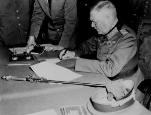 Marechal alemão Wilhelm Keitel no quartel-general russo em Berlim a assinar o documento de rendição que declarava que as hostilidades terminariam no dia seguinte.