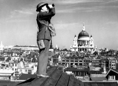 Um observador de aeronaves no telhado de um edifício em Londres com a Catedral de St. Paul em segundo plano.