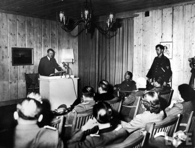Hitler roeado pela sua equipa a fazer um discurso na rádio para o povo alemão depois da tentativa de assassinato na Toca do Lobo.