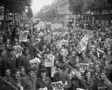 Militares e as mulheres americanas reúnem-se em frente do clube da Cruz Vermelha "Esquina Rainbow" em Paris para comemorar a rendição incondicional dos japoneses.