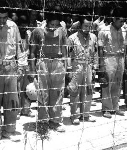 Prisioneiros de guerra japoneses em Guam, com a cabeça baixa depois de ouvirem o imperador Hirohito fazer o anúncio da rendição incondicional do Japão.
