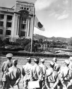 Bandeira japonesa a ser arriada durante a cerimónia de rendicação, no Edifício do Governo Geral.